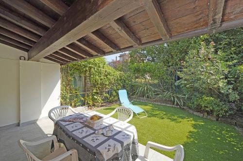 a patio with a table and chairs on a lawn at Villetta Gro - Gardagate in Sirmione