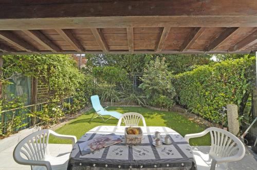 a patio with a table and chairs under a pergola at Villetta Gro - Gardagate in Sirmione