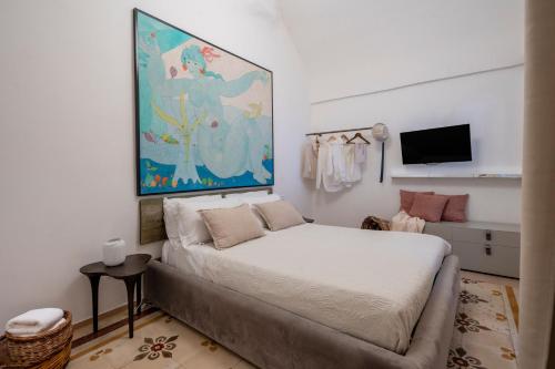 a bedroom with a bed and a painting on the wall at Dimora Sardaro Suites by BarbarHouse in Monopoli