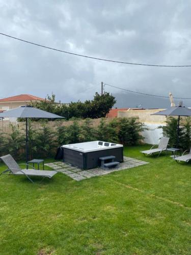 a backyard with a table and chairs and umbrellas at Casa Moderna in Fourfourás