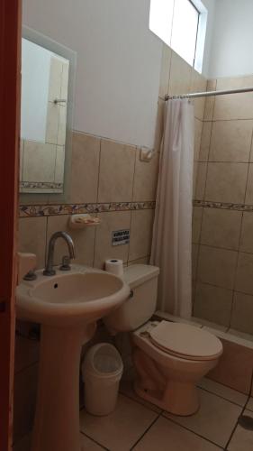 a bathroom with a sink and a toilet and a mirror at Tambo II Hotel Campestre in Cieneguilla