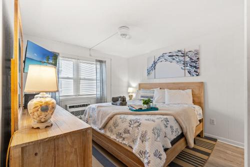 a bedroom with a bed and a table with a lamp at Lovely 2 bedroom condo with ocean view 304- 3rd Floor No Elevator in Myrtle Beach