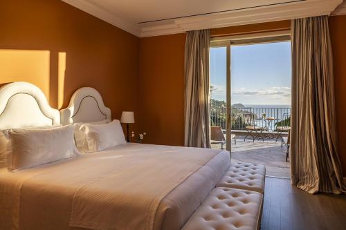 a bedroom with a large bed and a balcony at Villa della Pergola Relais et Chateaux in Alassio