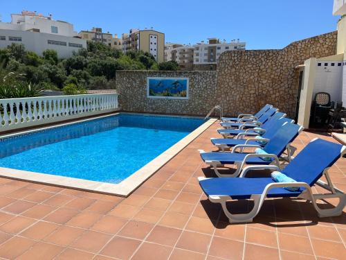 a row of lounge chairs next to a swimming pool at Villa Hermano with views and private pool in Lagos