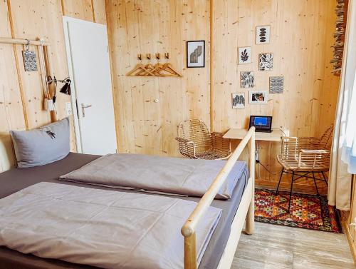 a bedroom with a bed and a desk with a laptop at Hacienda Rooms - moderne Zimmer in ruhiger Lage - Room only ! in Friedrichshafen