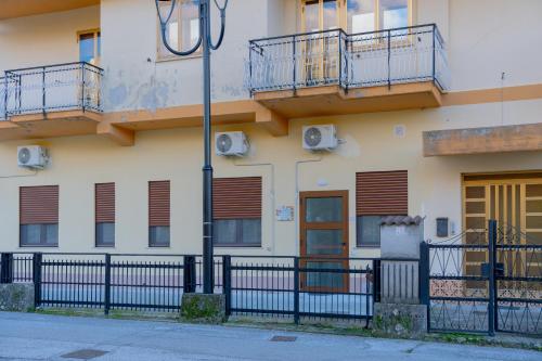a building with balconies and a fence in front of it at Il Sogno B&B Latronico Terme e Parco del Pollino in Latronico