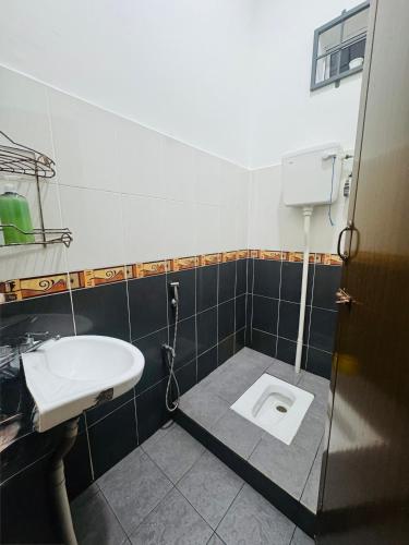 a bathroom with a sink and a toilet at Fath's Lodge in Dungun