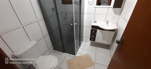 a bathroom with a shower and a toilet and a sink at Casa de Campo em Monte Verde in Camanducaia