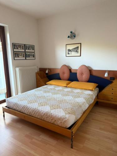 a bedroom with a large bed with yellow pillows at Casa Alba sul Lago in Dervio
