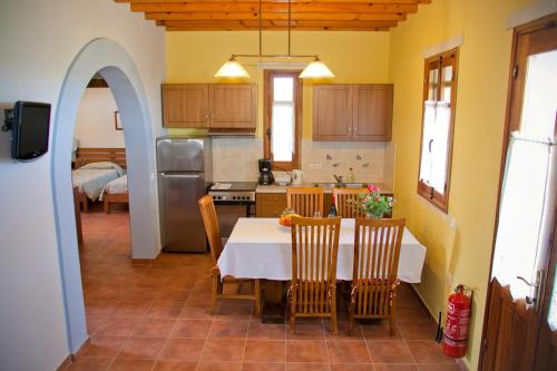 a kitchen and dining room with a table and chairs at Petroto Villas in Kiotari