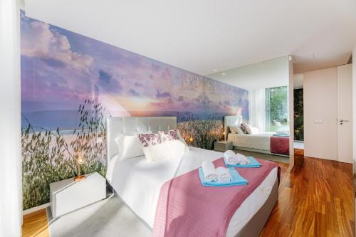 a bedroom with a bed and a painting of a beach at BestVillas Park Ofir in Esposende