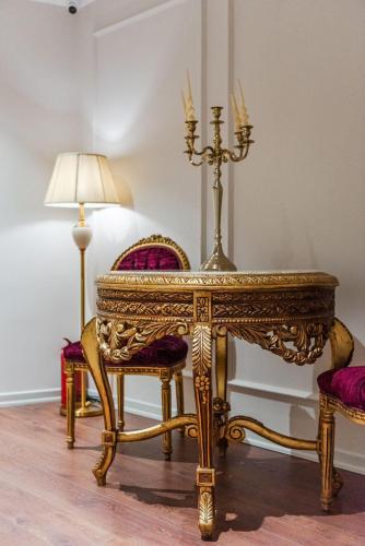 an ornate table with two chairs and a lamp at SOL INVICTUS Boutique Hotel Durres Albania in Durrës