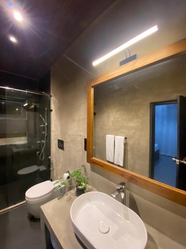 a bathroom with a sink and a toilet and a mirror at The Heavens Villa - Colombo & BIA Airport in Ja-Ela