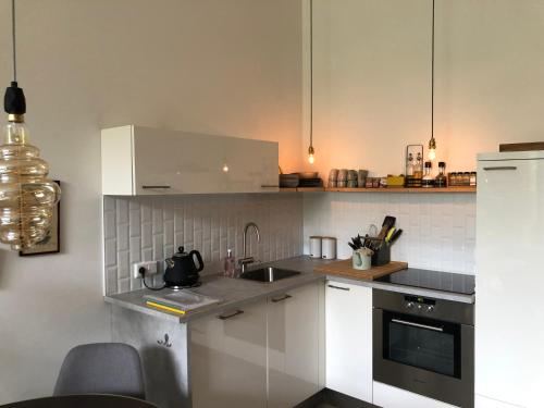 a kitchen with white cabinets and a sink at Luxurious appartement with sauna and kitchen in center of Dordrecht in Dordrecht