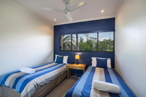 a bedroom with two beds and a window at Sunseeker Holiday Apartments in Sunshine Beach