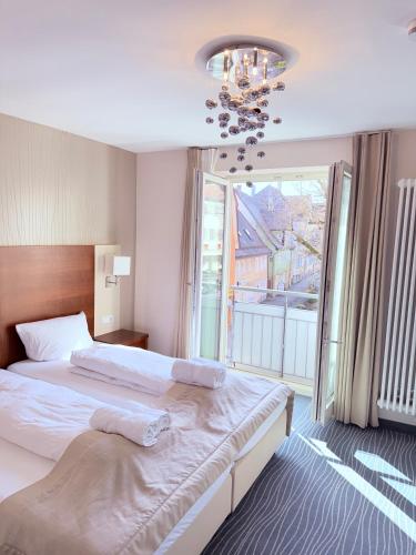 a bedroom with two beds and a large window at Krone Langenburg by Ammesso in Langenburg