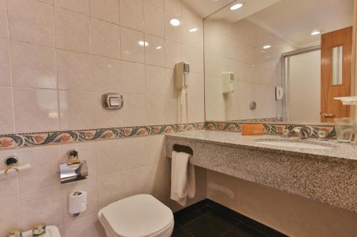 a bathroom with a toilet and a sink and a mirror at Gran Hotel Parana in Paraná
