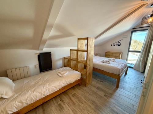 a bedroom with two beds and a tv in it at Chalet César in Risoul