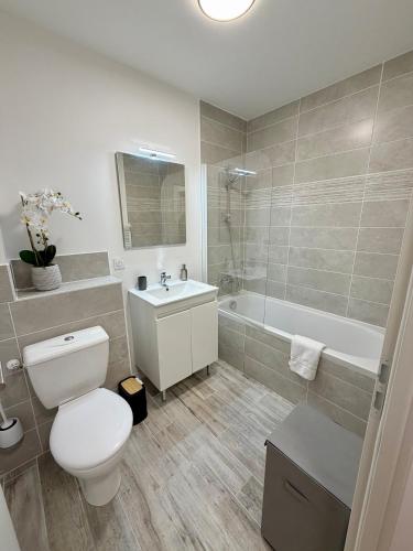 a bathroom with a toilet and a sink and a tub at Chalet César in Risoul