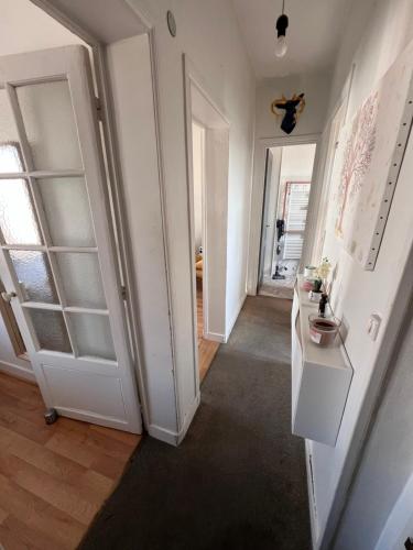 a room with a hallway with white cabinets and a door at Sejour paris parc des expositions in Vanves