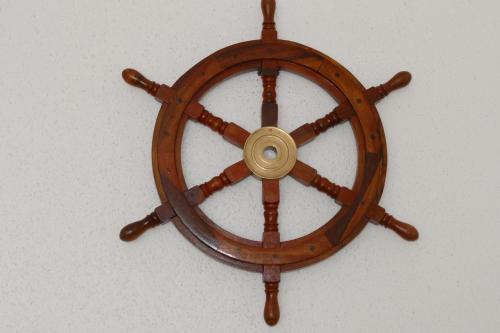 a wooden steering wheel on top of a wall at Kapitänshaus Schäfer App Bootsmann in Brunsbüttel