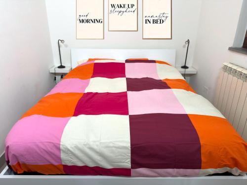 a colorful bed in a bedroom with posters on the wall at Residenza Frontemura in Montefalco