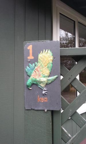 a sign with a bird on the side of a house at Arthur's Pass Alpine Motel in Arthur's Pass