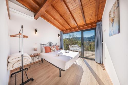 a bedroom with a bed and a large window at Casa da Portazinha - by Proguest in Amares