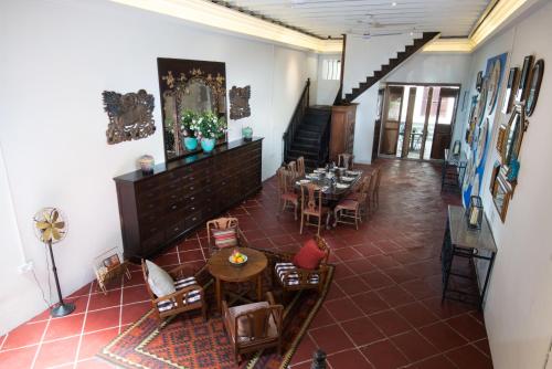 a room with tables and chairs and a staircase at Muntri Mews in George Town