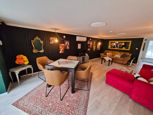 a living room with a table and a red couch at Richland Ráckeve in Ráckeve