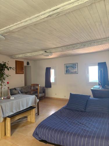 a bedroom with a blue bed and a couch at Bella Vista Cabris in Cabris