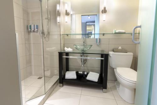 a bathroom with a shower and a toilet at Hôtel Must Aéroport de Québec par JARO in Quebec City