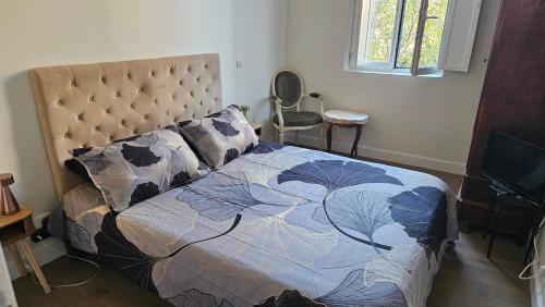 a bedroom with a bed with a quilt on it at Chambre chez l'habitant Res Belle Epoque Ville d'hiver in Arcachon