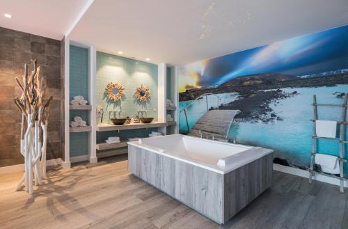 a bathroom with a large bath tub and a mural at Van der Valk Hotel Utrecht in Utrecht