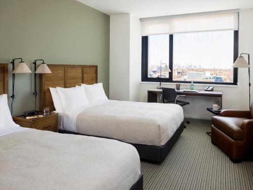 a hotel room with two beds and a desk and a chair at The Study at the University of Chicago in Chicago