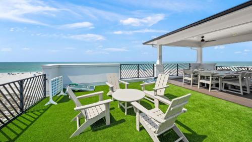 a patio with a table and chairs and the beach at The Pearl in Clearwater Beach