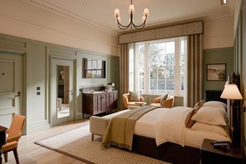 a bedroom with a large bed and a table and chairs at The Kithmore in St. Andrews