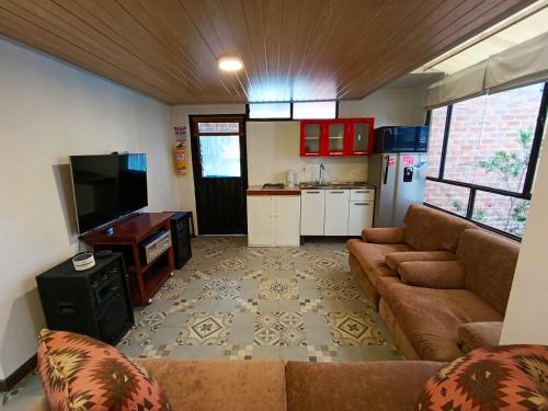 a living room with a couch and a kitchen at Casa San Andres Hostal in Pasto