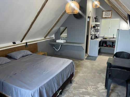 a bedroom with a bed and a sink and a kitchen at Condomíno dos Chalés in Porto Seguro