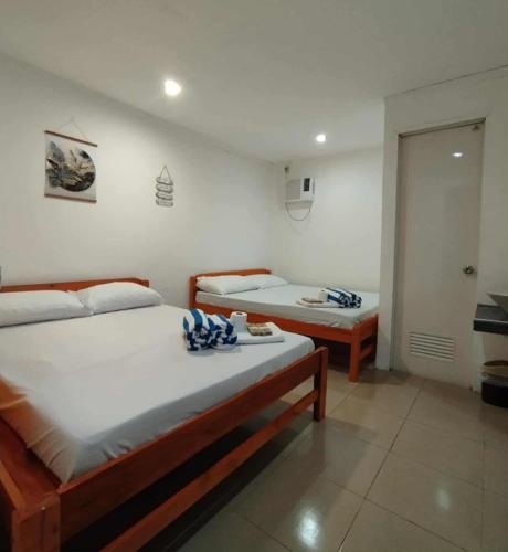 a bedroom with two beds with towels on them at RenSea Haven Boracay in Boracay