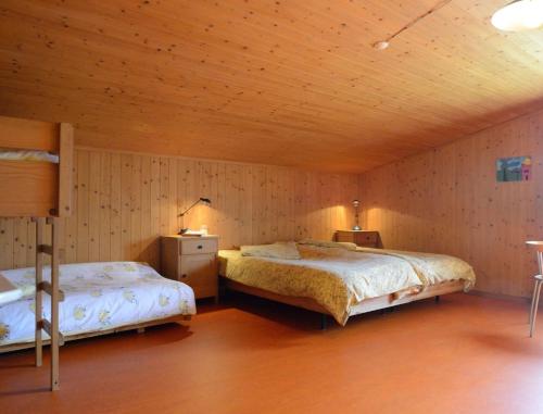 a bedroom with two beds and a wooden ceiling at Ferienwohnung Stirnimann-Gemsch in Valzeina