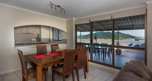 a kitchen and dining room with a table and chairs at Coral Towers Holiday Suites in Cairns