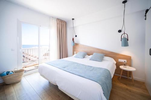 a bedroom with a large bed and a large window at Blanca by Uephotels in Can Picafort