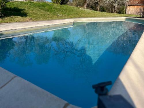 a swimming pool with blue water in a yard at Gites Le Pagus in Simeyrols
