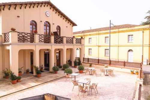 a courtyard of a building with tables and chairs at Albergo Al Cinghiale in Montevecchio