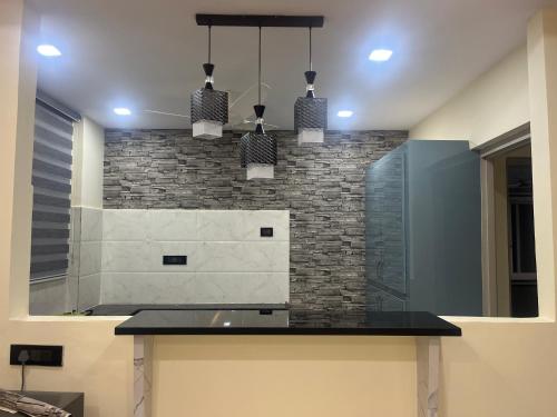 a kitchen with a counter and two pendant lights at Beach front flat in Bhīmunipatnam