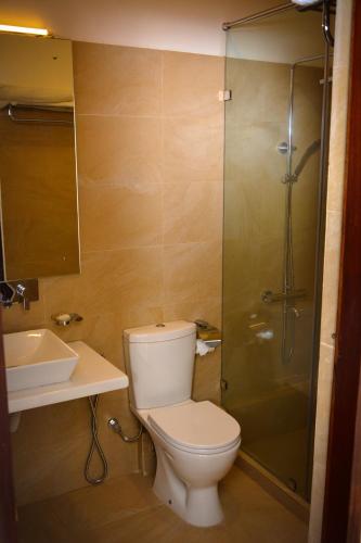 a bathroom with a toilet and a shower and a sink at Sunset Fort Galle in Galle