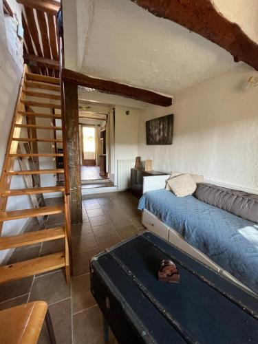 a bedroom with a bed and a staircase in a room at Le Gite des Anges du Verdon in Trigance