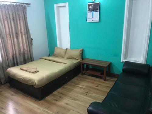 a bed and a chair in a room with blue walls at Konjyosom Homestay-Experience Real Nepali Hospitality in Kathmandu