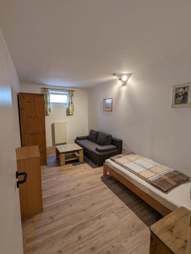 a living room with a bed and a couch at Souterrainwohnung in Kelheim